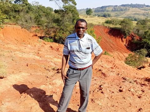 Mr. Dlamini standing next to a donga that is threatning livelihoods in his community.
