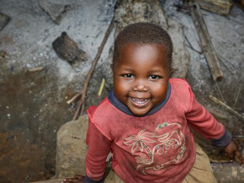 4-year-old Hortense smiles and plays outside her house.