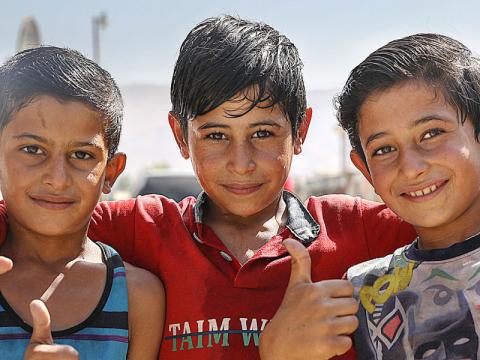 Three boys smile.