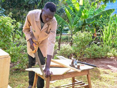 Nathan Kipyego is a youth lead farmer implementing FMNR in Elgeyo Marakwet County and has now turned his beekeeping skills into a source of income. ©World Vision Photo/ Hellen Owuor