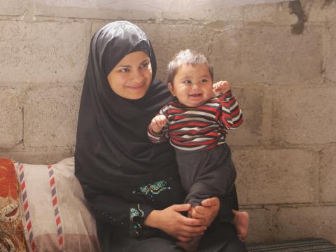 Shaima happily sitting with her now healthy son. 