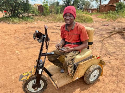 Aimé in his wheelchair received from World Vision