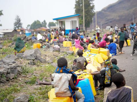 Photo of scene of children and adults waiting to fetch water