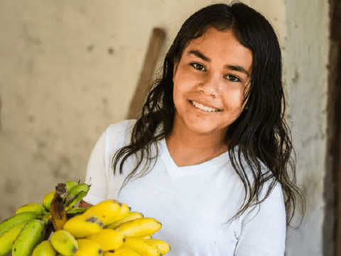 Girl holding a bunch of bananas