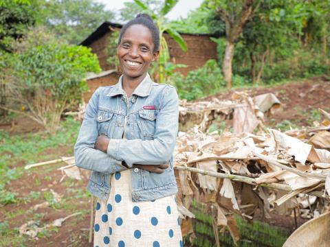 Aberash in her garden smiling proudly