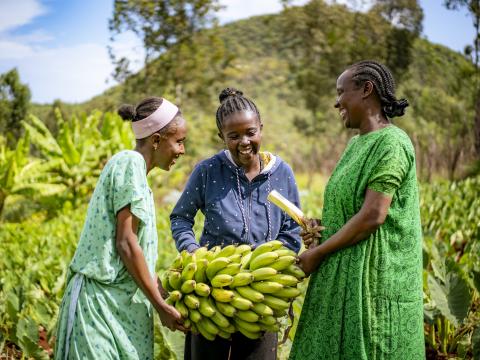 Martha and her children smiling holding banana branch
