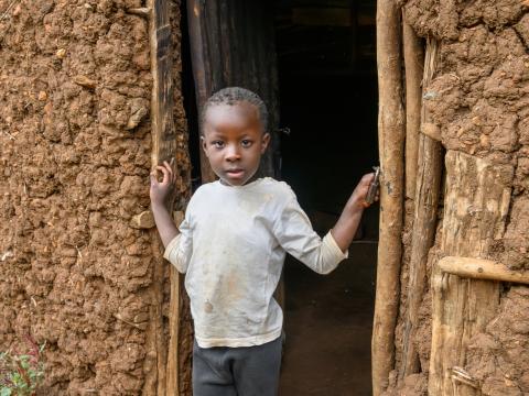 Joy, 4, stands in a doorway, Kenya