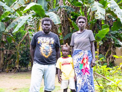 The family standing next to their backyard gardening