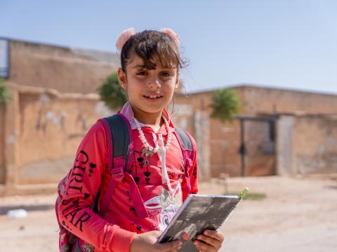 Amal* holding her book, ready for class