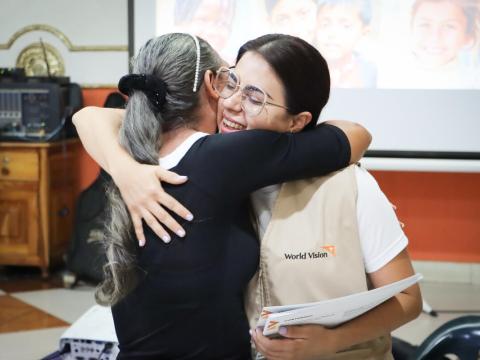 World Vision staff embraces a participant in programmes in Venezuela 
