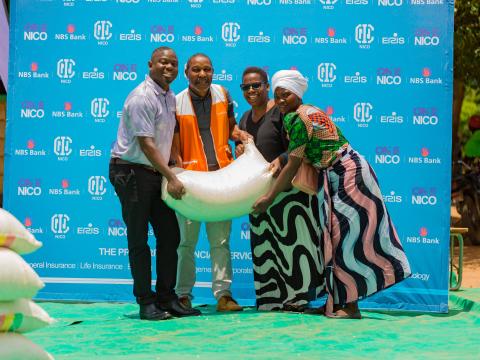  NICO Life Insurance Company’s Chimwemwe Kanyenda and World Vision Malawi’s Charles Chimombo hand over relief maize to a Machinga District Council official