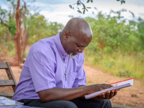 A faith leader prays over a book