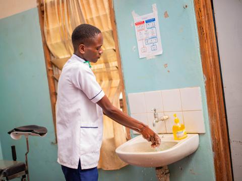 Felix Kadzanja, a Nurse-Midwife Officer at Nambazo Community Health Center cleaning his hands after performing  a medical procedure