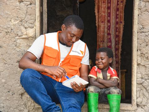 Ephrem, aged 4, talks to Godriche (in WV vest), a World Vision staff. 