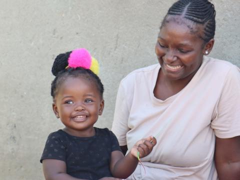 Qondile smiling with her daughter after a routine visit from a rural health motivator. 