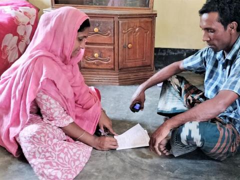 A man and a woman sitting on a floor, discussing a family budget