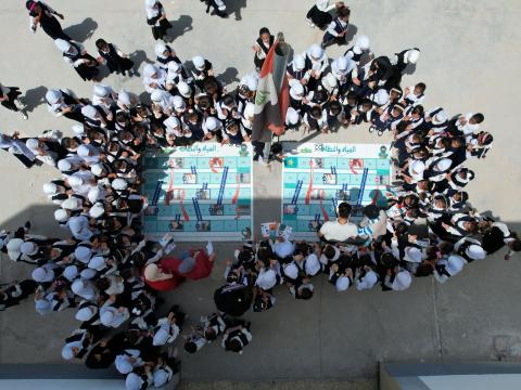 Aerial shot of group of children playing Arabic version of snakes and ladders