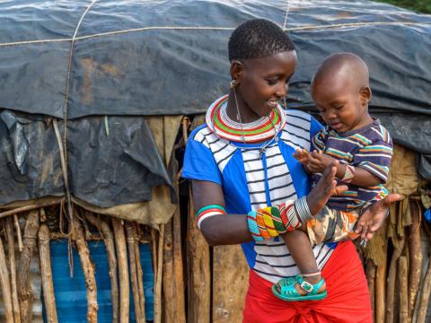 Sixteen-year-old Sameli holds her 18-month-old son, Jamline outside their home. 