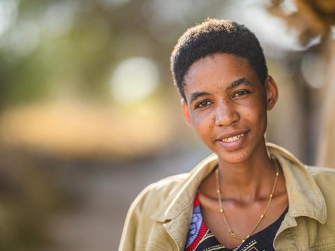 Young woman standing outside parent's home