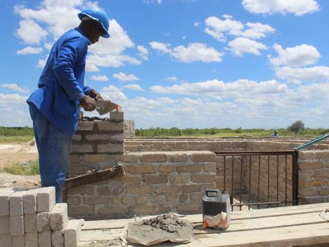Patrick laying bricks during construction work at Tongogara Refugee Settlement