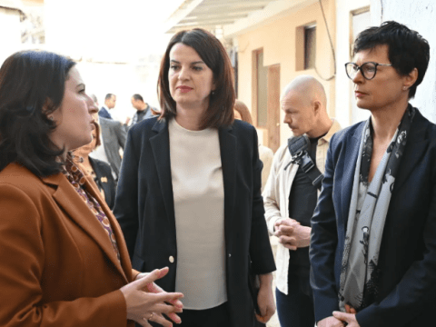 Three women dressed professionally standing and talking together