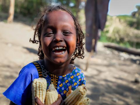 Tamiro laughing and holding corn