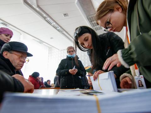 Group of adults waiting to get cash voucher assistance