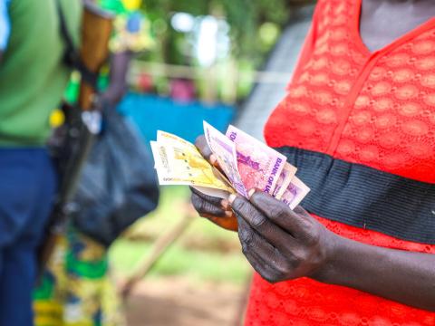 Woman in a red and black top, holding money