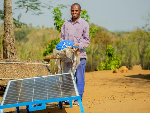 Njanjama with his solar-powered water pump, showing his farming progress