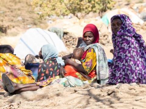Hawa sits holding her baby