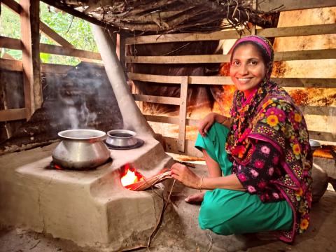 Shahida cooks a meal for her family using an energy-efficient, eco-friendly cooking stove in Sarankhola, Bangladesh.