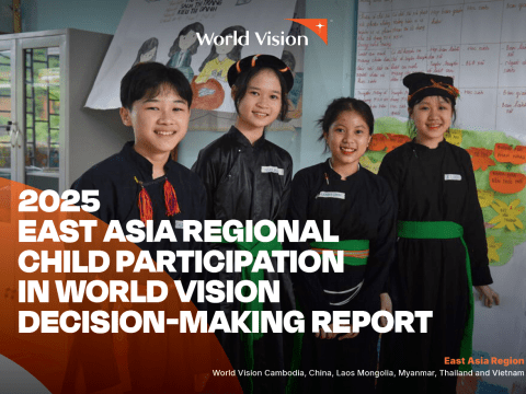 Four children stand together in a classroom wearing traditional clothing, with educational posters and handwritten charts displayed on the walls behind them. The image appears on the cover of the 2025 East Asia Regional Child Participation in World Vision Decision-Making Report.
