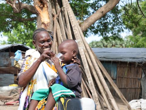 Nyabon gives her son Khalid clean water to drink