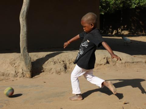 Five-year-old Trangelito kicks a football outside his home