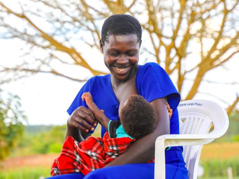 A mother smiles down at her baby while breastfeeding