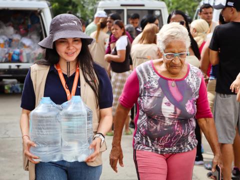 A World Vision staff member assists a resident during the distribution of emergency supplies in La Guaira, the state hardest hit by the earthquakes.