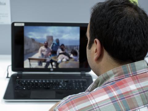 Ahmad looking at a photo of him and his family on a picnic in Syria before the war