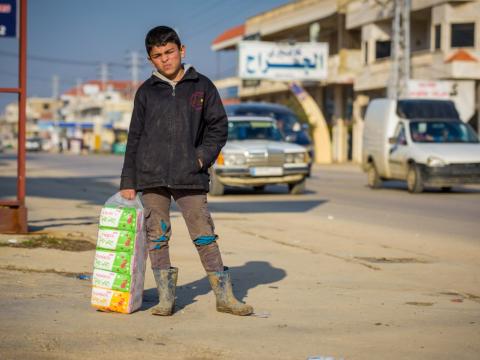 Ali, a Syrian refugee boy in the Bekaa Valley of Lebanon, sells tissues on the street to earn money for his family.