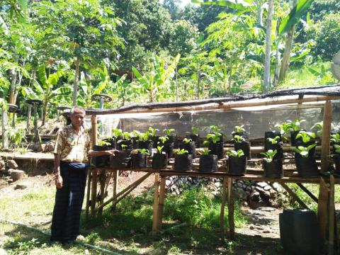 Bapak Jony stands in front of his home garden.