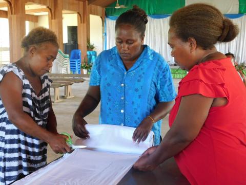 Fulisango community members preparing fabric for dyeing