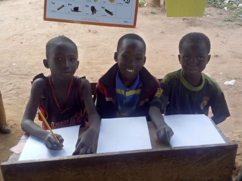 Children smile at a Literacy Boost reading club in Ghana