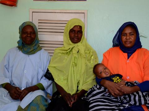 Mariem(in the left), sitting next to the Aminata, mother of baby Ibrahim, 2 months old , whom she helped giving birth, and Mama Aisha a retired cook who became volunteer with her at the Deba Hijaj Health center : Coumba Betty Diallo, © World Vision 2016.