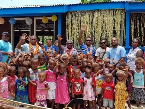 The visiting delegation and children in front of the Kwai ECE Centre.