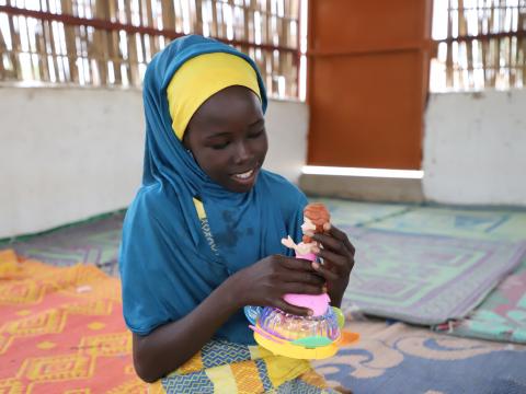 Fanna playing with her doll in the Child Friendly Space of Sayam Forage in Diffa, Niger