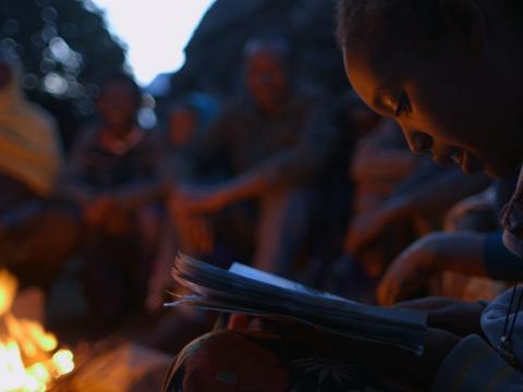 Tizta, 9, reads a story to her family outside their home in Ethiopia Tizta, 9, reads a story to her family outside their home in Ethiopia