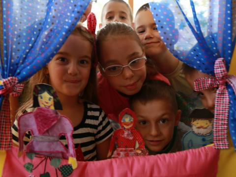 The House of Joy stays true to its name – children are now gathered in a circle and they are participating in a small-scale puppet show. 