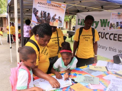 Teachers and students try the spelling activity at the World Vision booth.