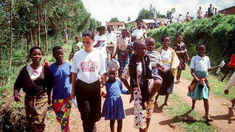 WVI Employee walking with children during Rwandan Genocide