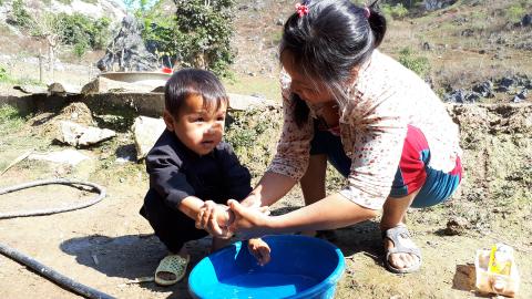 A mother washes her baby's hand in Viet nam