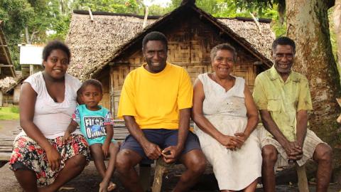 •	John (centre) is the REACH project faith leader. His family (pictured) is proud that he champions gender equality. 